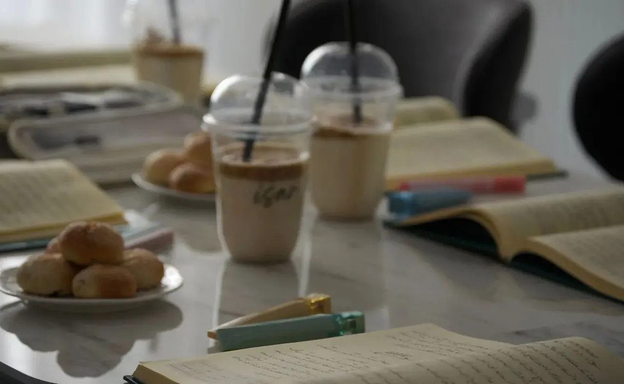 ノートや資料が広がるカフェのテーブル